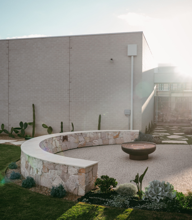 Natural stone wall and fire pit installation by Isidore Landscapes