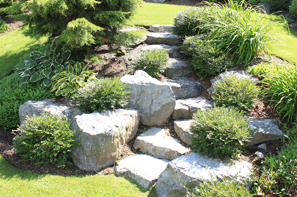 Natural stone installation by Sylvita Landscaping featuring flagstone and stone walls